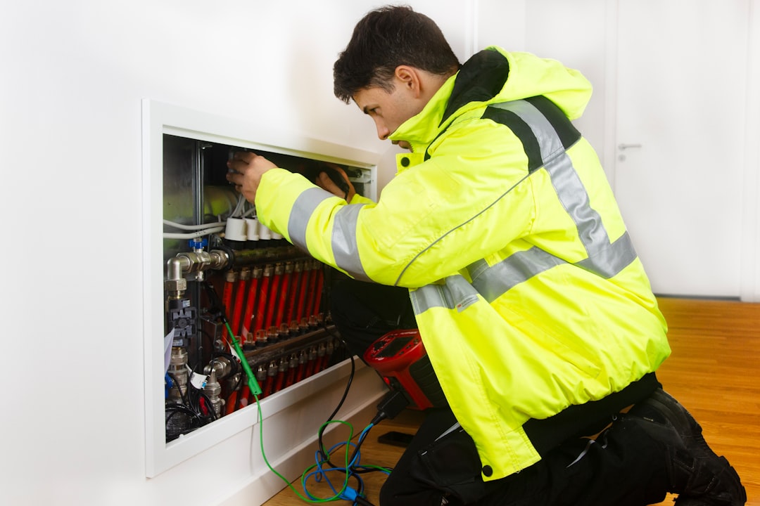 Ein junger Handwerker arbeitet an einer Fußbodenheizung.